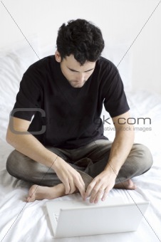Young man using laptop in the bedroom