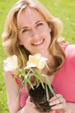 Woman outdoors holding flowers smiling