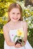 Young girl outdoors holding flower smiling