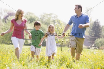 Family walking outdoors holding hands smiling