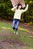 Woman outdoors jumping with umbrella smiling