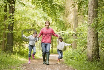 Father and daughters walking on path holding hands smiling