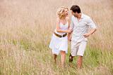 Couple walking outdoors holding hands smiling