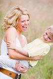 Mother holding son outdoors smiling