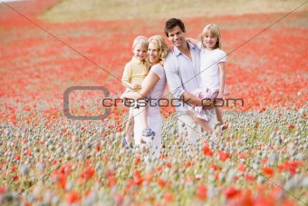 Family standing in poppy field smiling