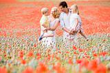 Family standing in poppy field smiling