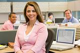 Businesswoman in cubicle smiling
