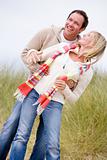 Couple standing on beach smiling