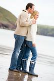 Couple standing on beach smiling