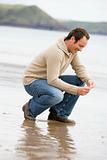 Man crouching on beach smiling