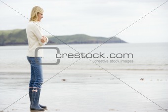 Woman standing on beach smiling