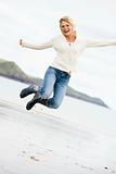 Woman jumping on beach smiling