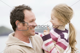Father and daughter at beach smiling