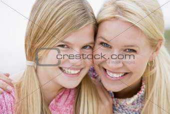 Mother and daughter at beach smiling