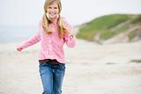 Young girl running at beach smiling