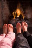 Children's feet warming at a fireplace