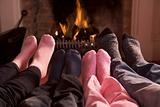 Family of Feet warming at a fireplace