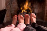 Children's feet warming at a fireplace