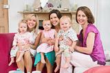 Three mothers in living room with babies smiling