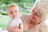 Grandmother outdoors on patio with baby smiling
