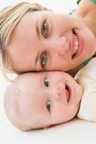Mother and baby lying on floor smiling