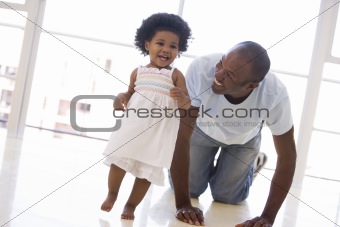 Father and daughter indoors playing and smiling