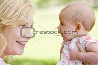 Mother and baby outdoors smiling