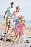 Family running at beach smiling