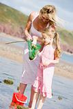 Mother and daughter at beach fishing and smiling
