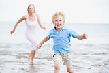 Mother and son running on beach smiling