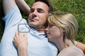 Couple lying outdoors sleeping