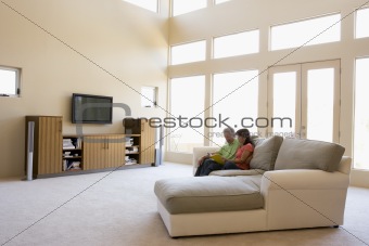 Couple reading book in living room