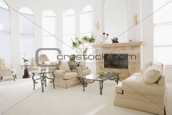 Woman reading magazine in living room