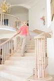 Woman going up staircase in luxurious home