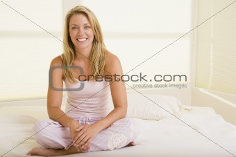 Woman sitting in bedroom smiling
