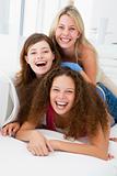 Three women in living room playing and smiling