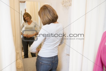 Woman trying on jeans and smiling