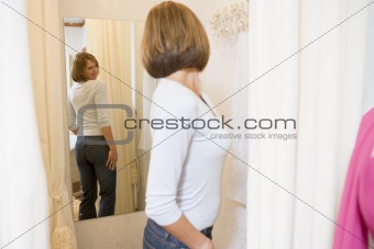 Woman trying on jeans and frowning