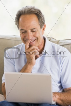 Man in living room with laptop smiling