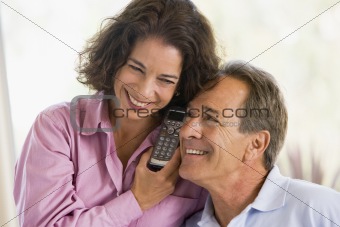 Couple indoors using telephone smiling
