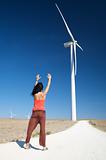 woman greeting wind energy mill