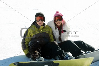 Couple teen snowboarders