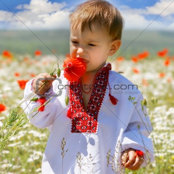 baby boy in traditional clothes in flowers