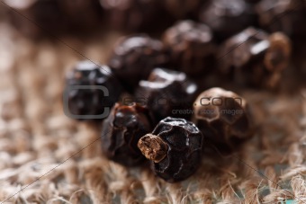 black peppercorns on a hessian background, super macro