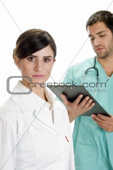 busy doctor looking writing pad and nurse looking you