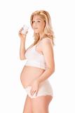 Pregnant blonde woman in white with glass of milk