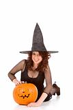 Teen girl in Halloween hat with carved pumpkin  (focus on pumpki
