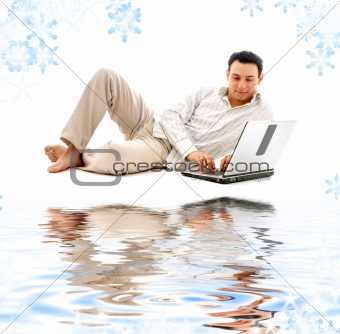 relaxed man with laptop on white sand