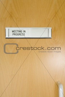 A Closed Office Door, With 'Meeting In Progress' Sign