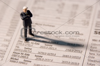 Figurine Of A Businessman With Arms Crossed Standing On A Financ